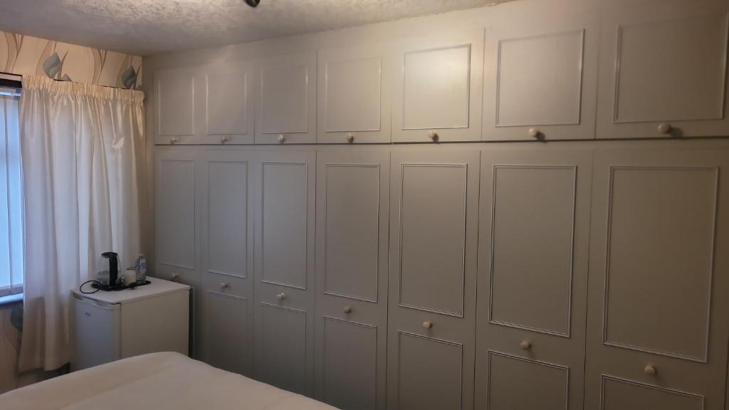 ein Schlafzimmer mit weißen Schränken und einem Bett in der Unterkunft Ansty view in Coventry