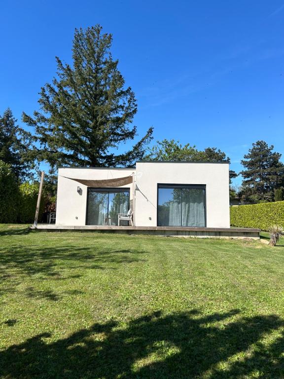 a white house with a large yard at Cocon proche de Lyon in Neyron