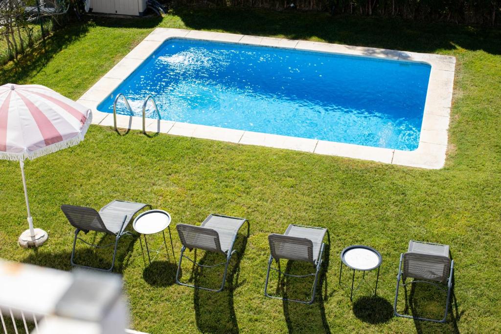 an overhead view of a pool with chairs and an umbrella at Jacarandas Islantilla in Islantilla