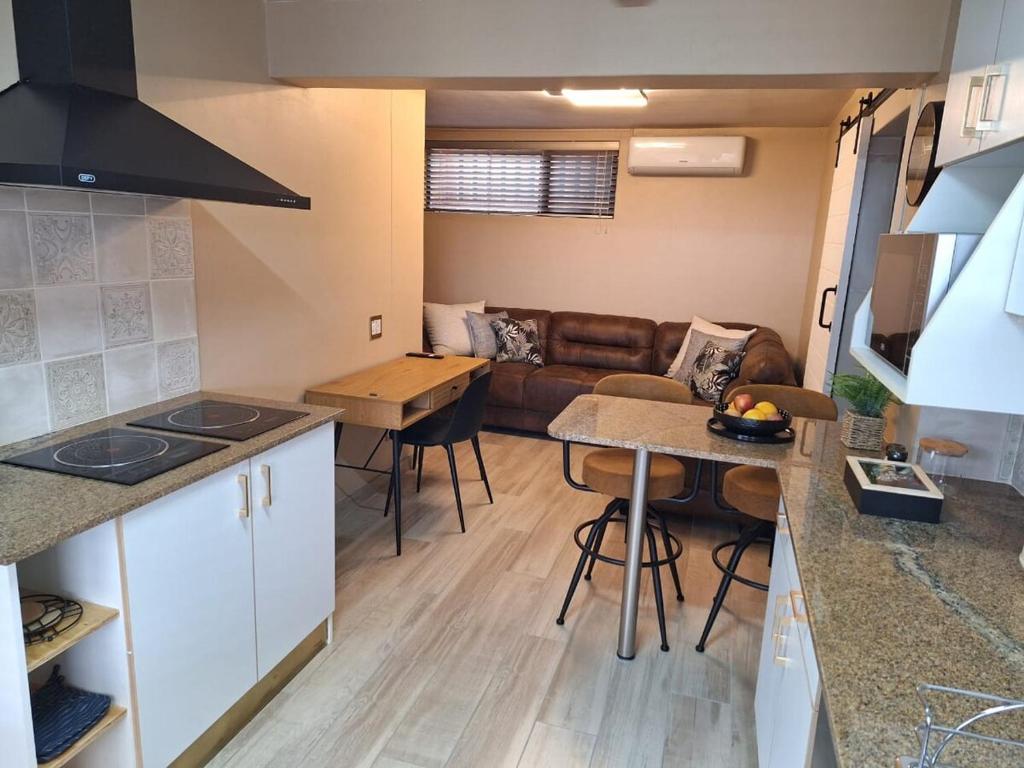 a kitchen and living room with a couch and a table at Lovista in Tygerberg Hills