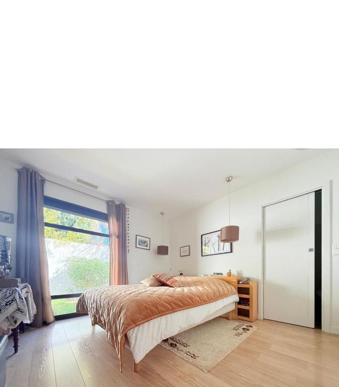 a bedroom with a bed and a large window at Villa sympa calme in Casablanca