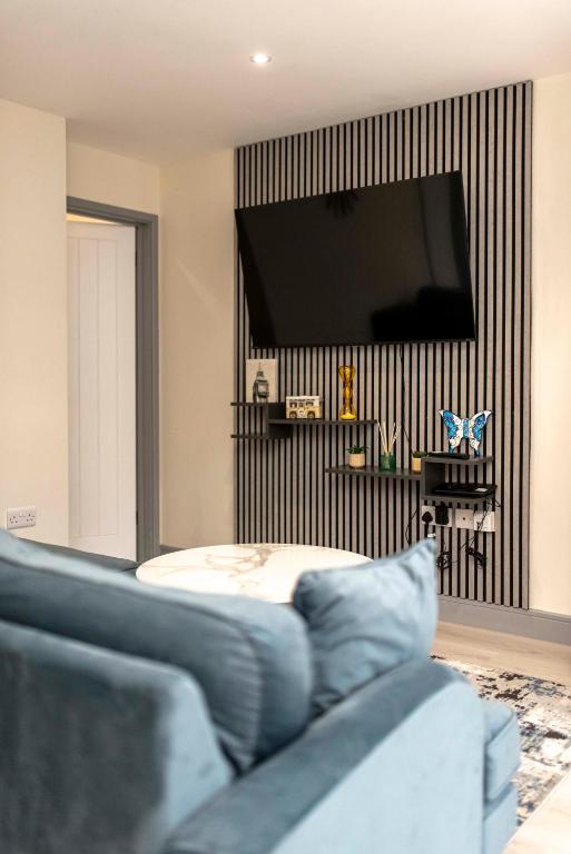 a living room with a tv and a couch at The Burleigh palace in Cambridge