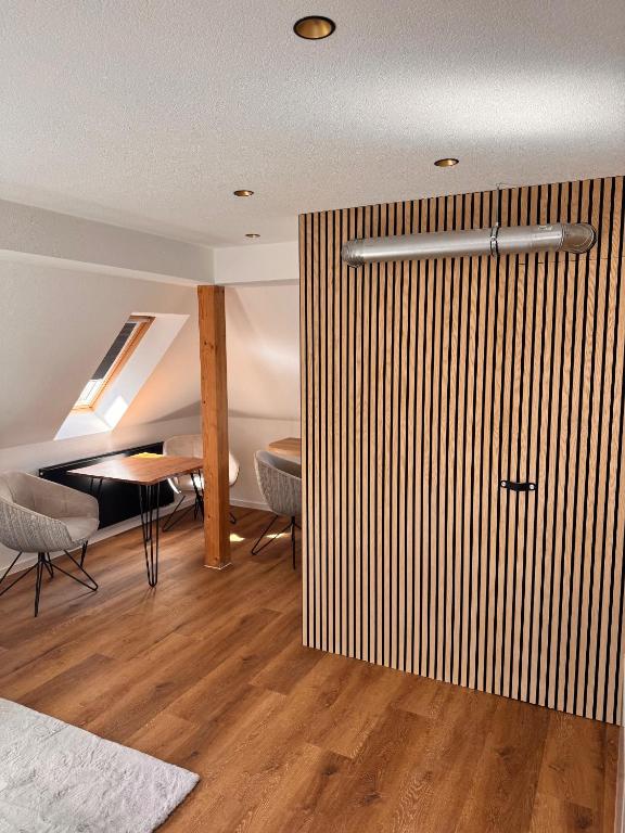 a room with a sliding door with a table and chairs at Design Dachgeschoss Wohnung in Eilenburg
