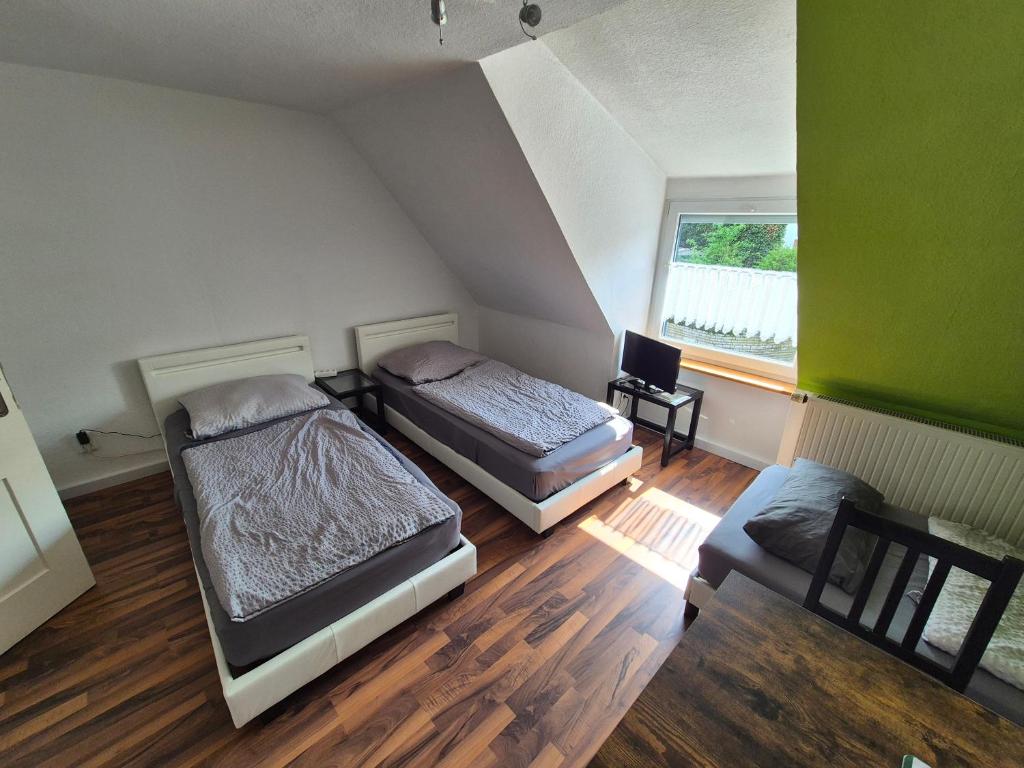 a room with two beds and a chair and a window at Zimmervermietung Müller in Kelheim