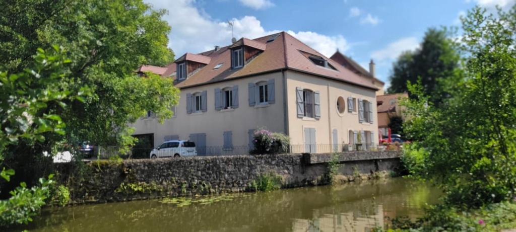 a house on a bridge next to a river at Studio de l'Armançon in Semur-en-Auxois