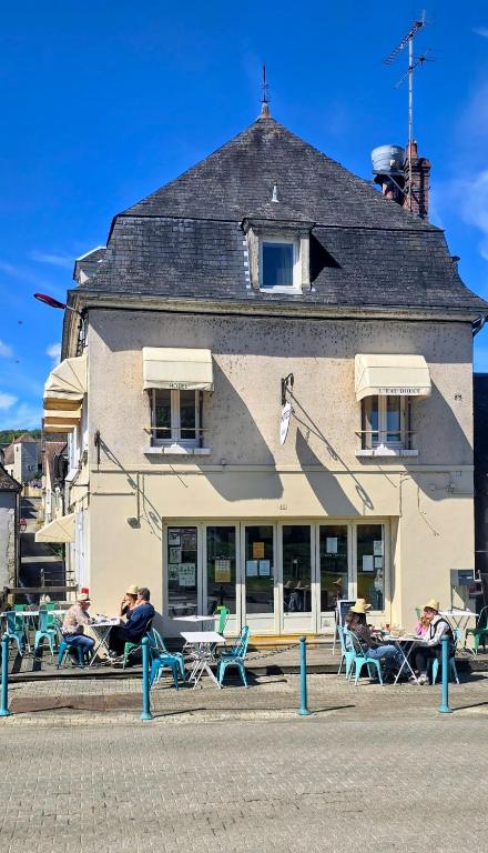 a building with people sitting on benches in front of it at L eau douce in Ménétréol-sous-Sancerre