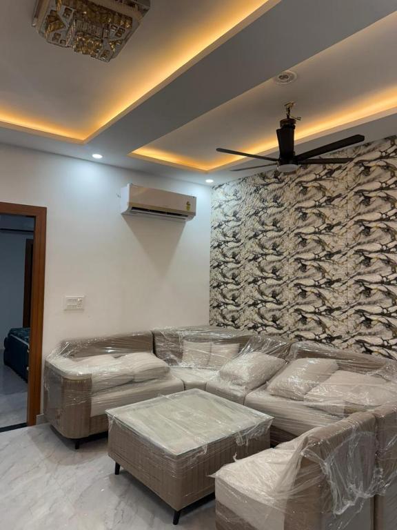 a living room with a couch and a stone wall at Aanya Bnb in Zirakpur