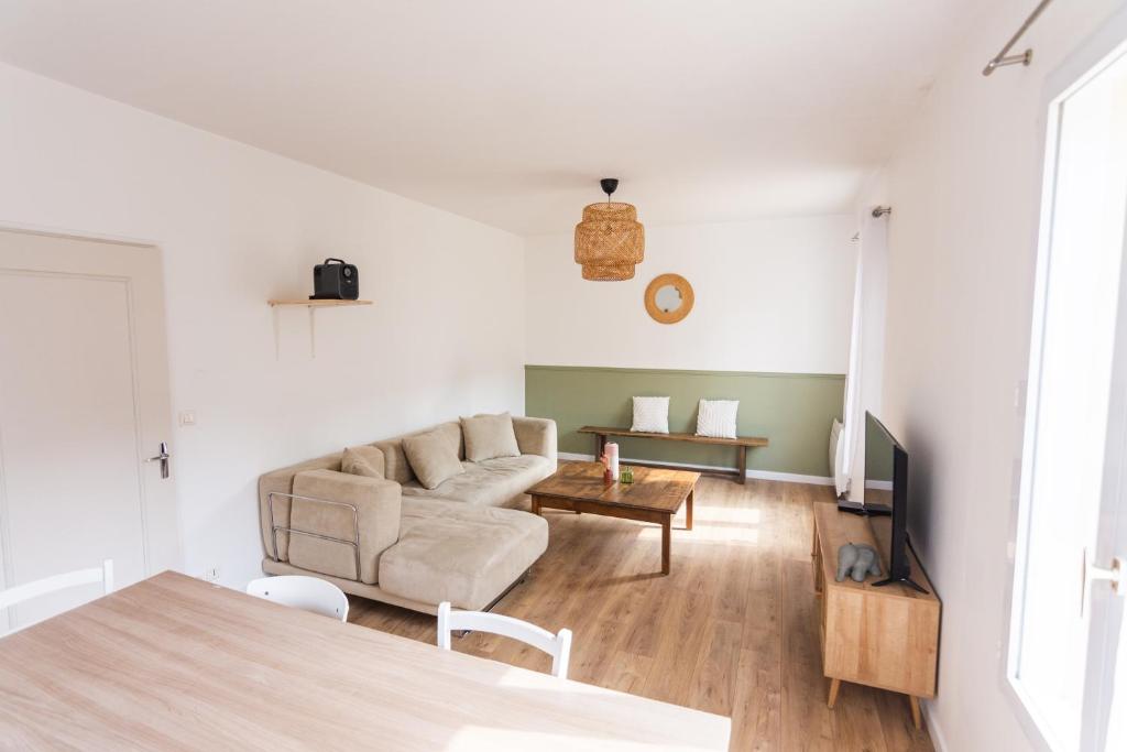a living room with a couch and a table at Maison avec parking la Flocellière in La Flocellière