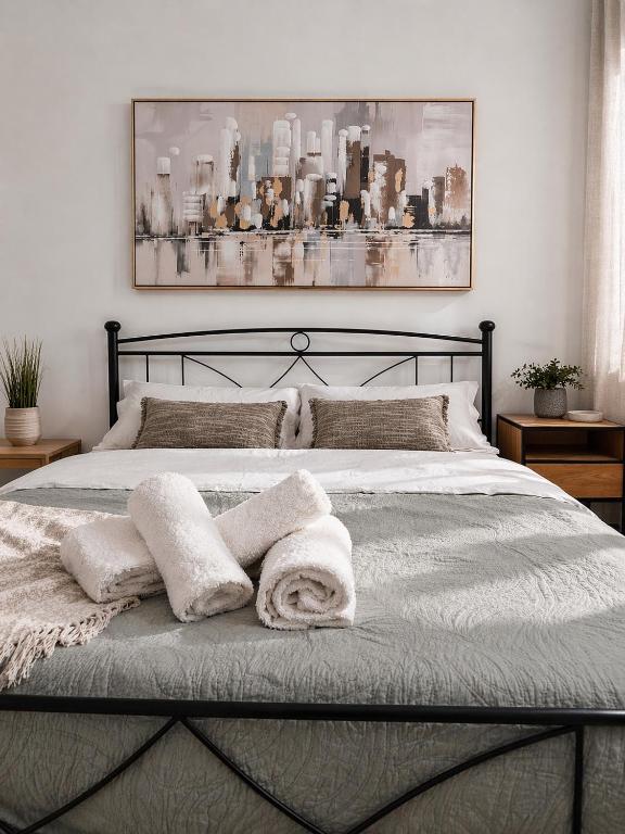 a bedroom with a bed with towels on it at Olive tree Apartment Kanoni in Kanoni