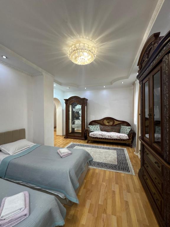 a bedroom with two beds and a chandelier at spacious apartment in Almaty