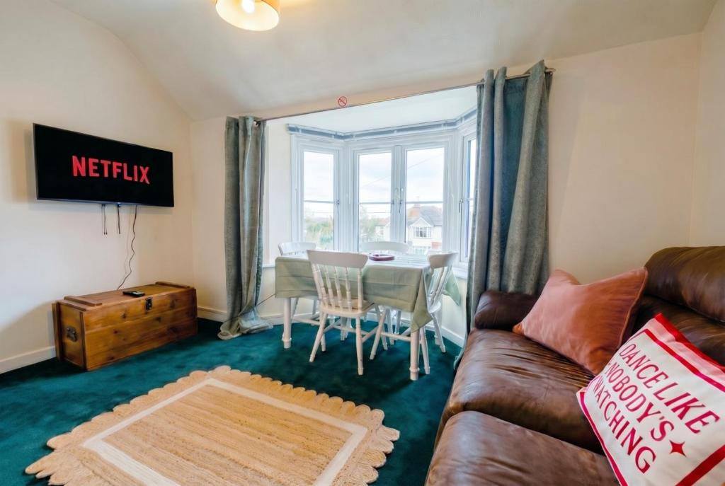 a living room with a couch and a table at New Forest Flat Steps from Brockenhurst Station, Sleeps 4 in Brockenhurst