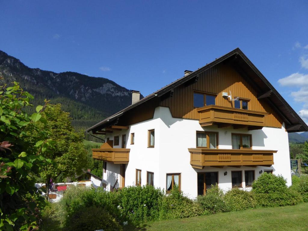 een wit huis met houten balkons op een berg bij Haus Siebenbruenn in Sankt Stefan an der Gail