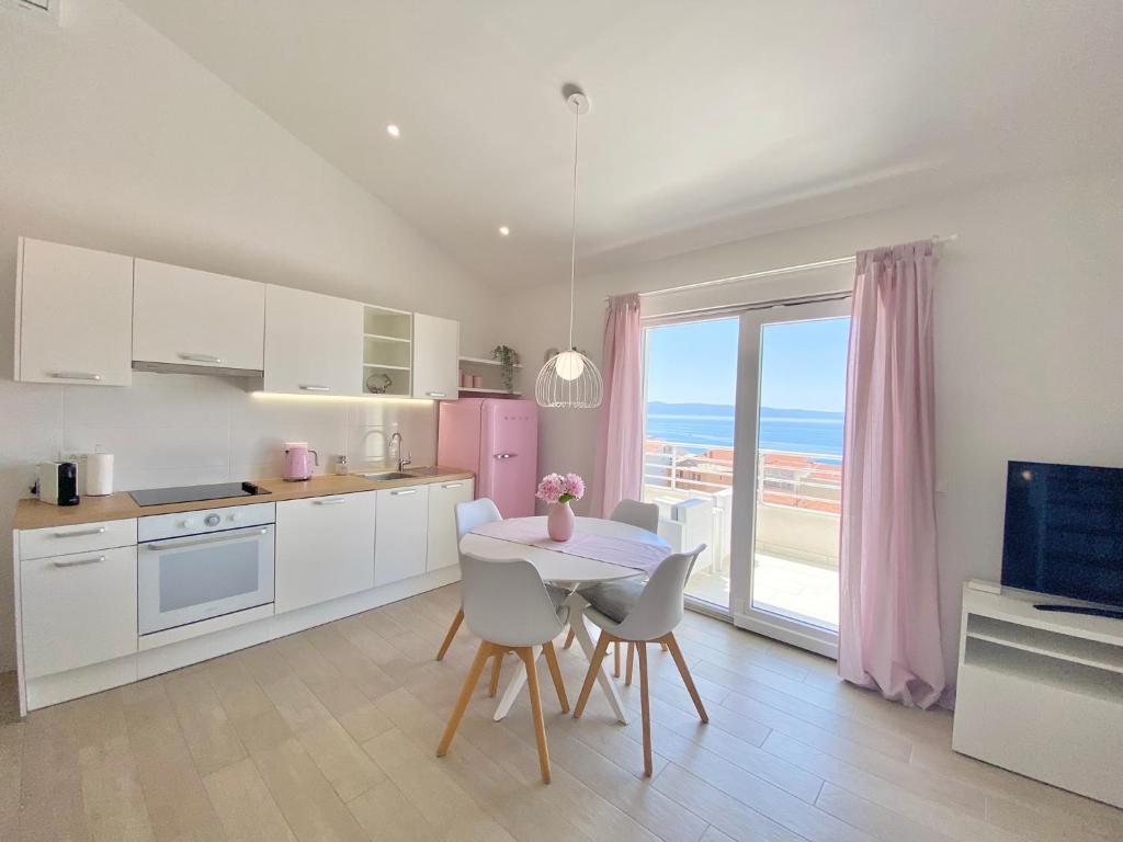 a kitchen with a table and chairs and a dining room at Ksenija Deluxe Residence in Tučepi