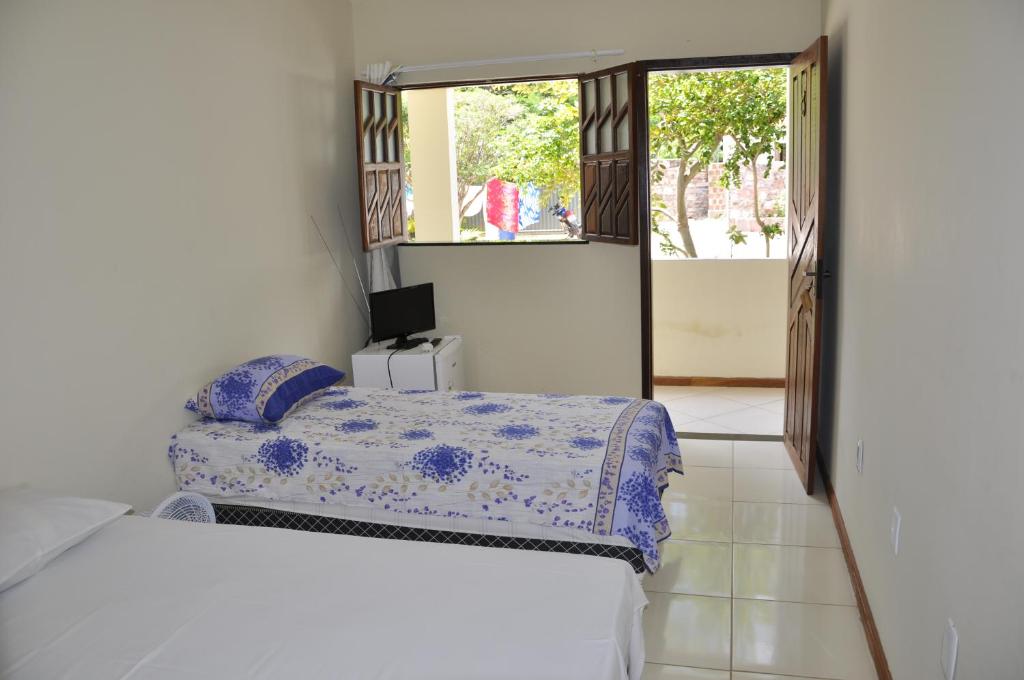 a bedroom with two beds and a door to a balcony at Pousada Mirantes Do Sincorá in Mucugê