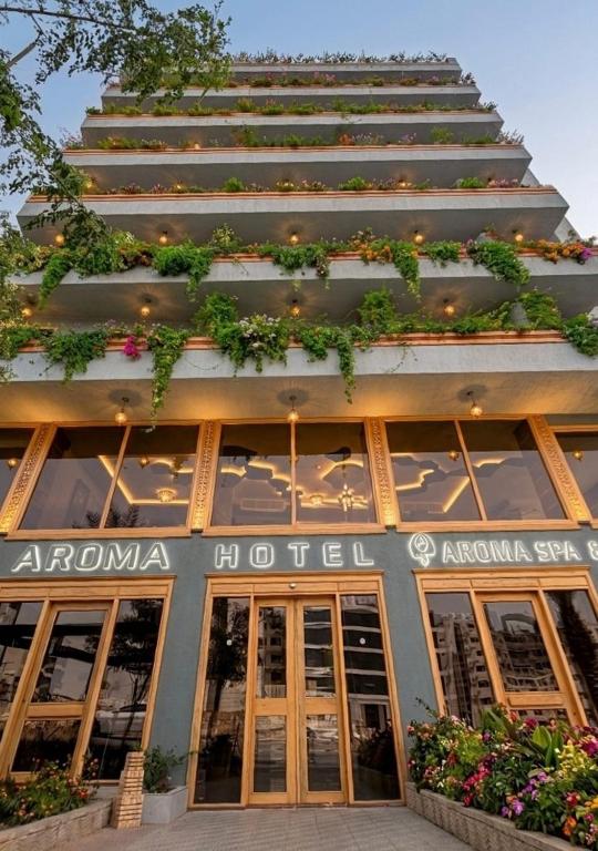 ein hohes Gebäude mit vielen Pflanzen darauf in der Unterkunft Aroma Hotel in Aqaba