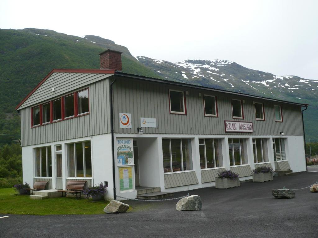 un edificio di fronte a una montagna innevata di HI Borlaug Vandrerhjem a Borgund