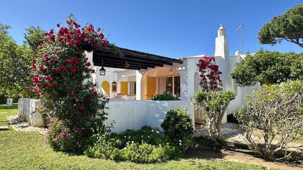 a white house with flowers in front of it at Golfe - Shared Pool - 7 Pax - Vilamoura in Vilamoura