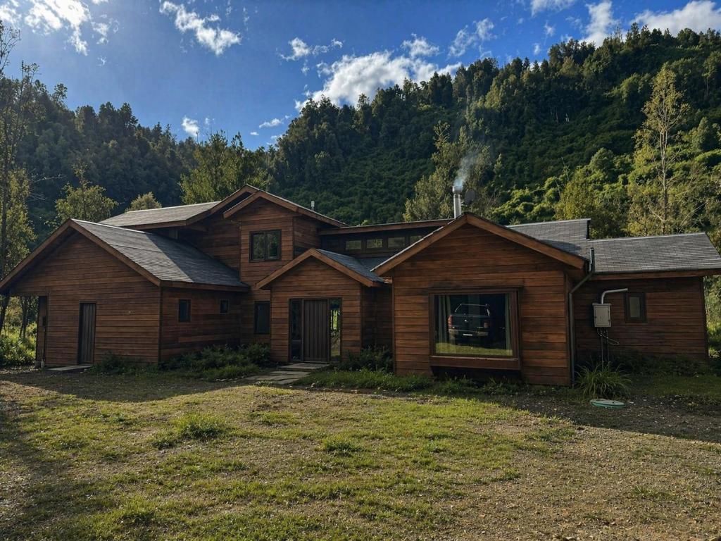a wooden house with a mountain in the background at Casa Mayay in Ranco