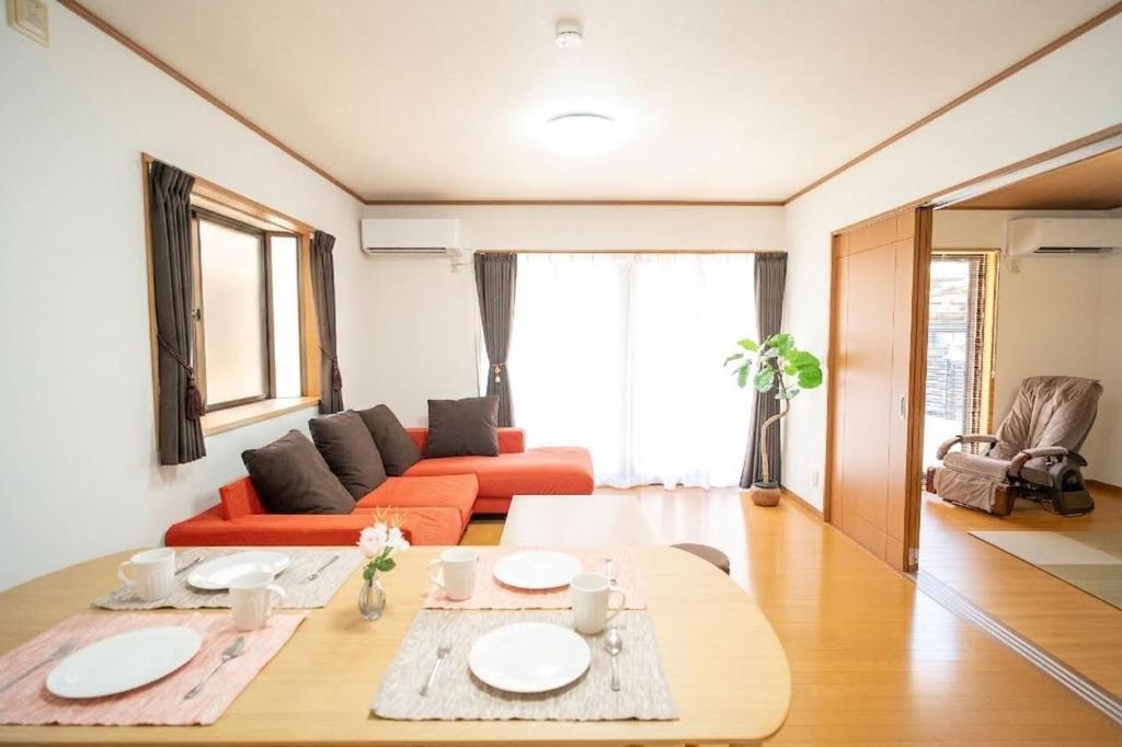 a living room with a couch and a table at Max13ppl Family-Friendly , 110sqm , SpaciousLiving&4BRM , LongStay OK , 2CarPark , 25min to NAGOYA & LEGO & Outlet in Yatomi 