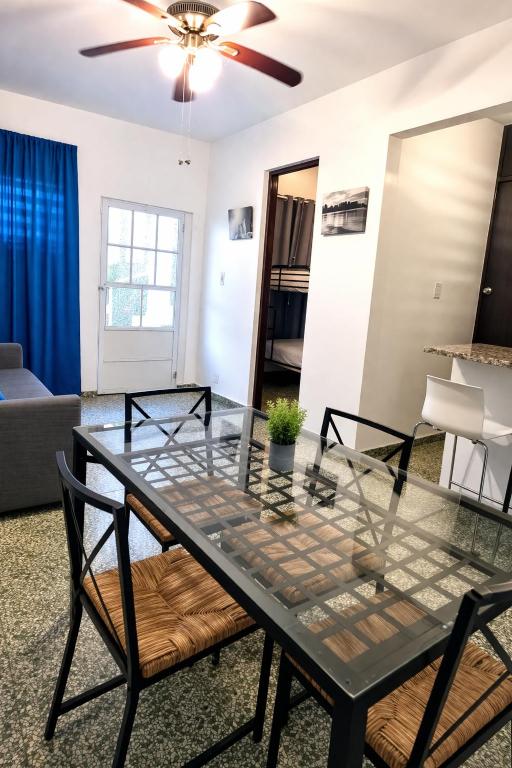 a dining room with a glass table and chairs at Emmanuelli Sur 7 Bedroom Mall of San Juan Home in San Juan