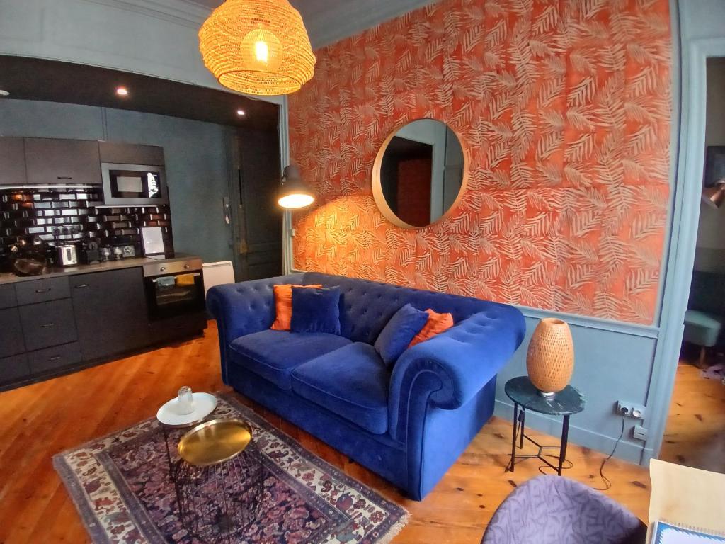 a living room with a blue couch and a mirror at Le repaire de Rougemare déco soignée et chaleureuse, WIFI haut débit en plein centre historique in Rouen