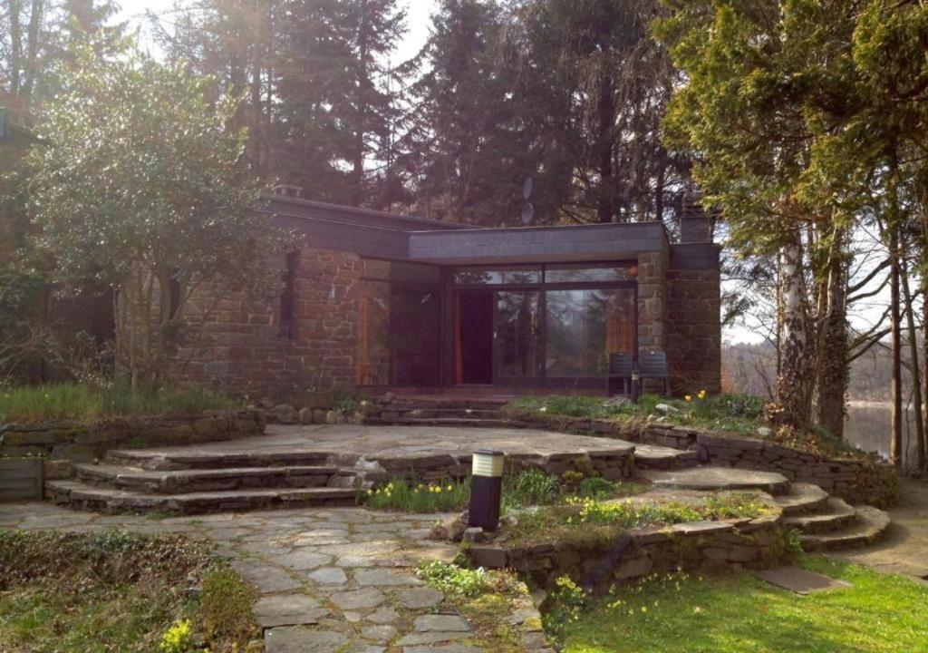 a brick building with a stone patio and stairs at Domaine Heyen in Waimes