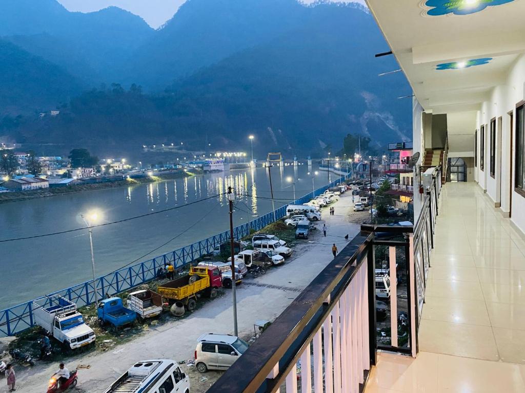 a city with cars parked on a street next to a river at The HIGHLIGHT STAY in Uttarkāshi