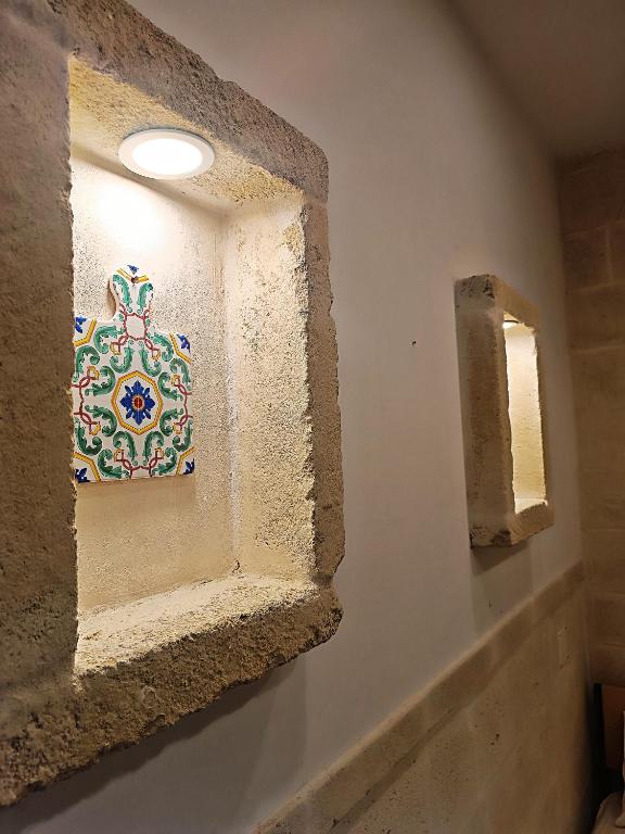 a bathroom with a mosaic tile on the wall at Minuetto 60 in Ostuni