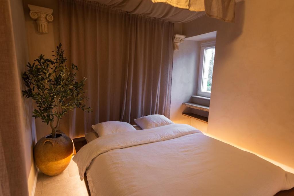 a bedroom with two beds and a vase with a plant at Villa Hermès in La Flocellière
