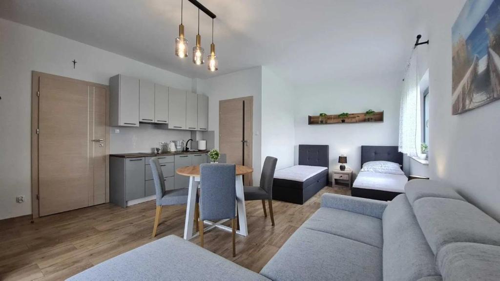 a living room and kitchen with a couch and a table at Rajska Zatoka Jantar in Jantar