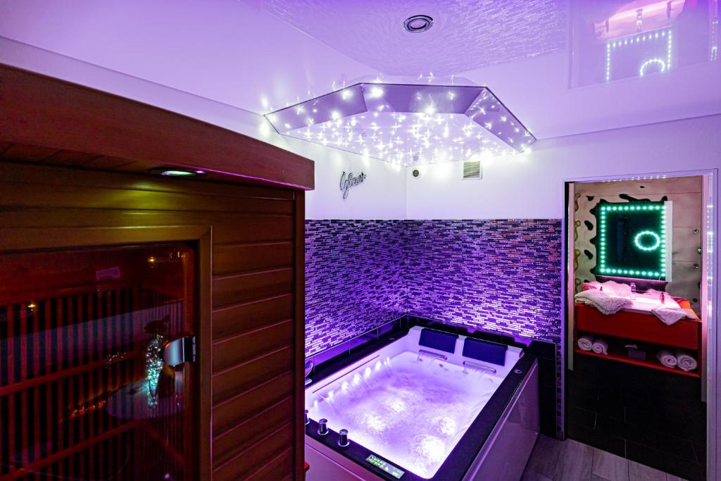 a hot tub in a room with purple lighting at "glamappartspa" design experience & Parking in Dijon