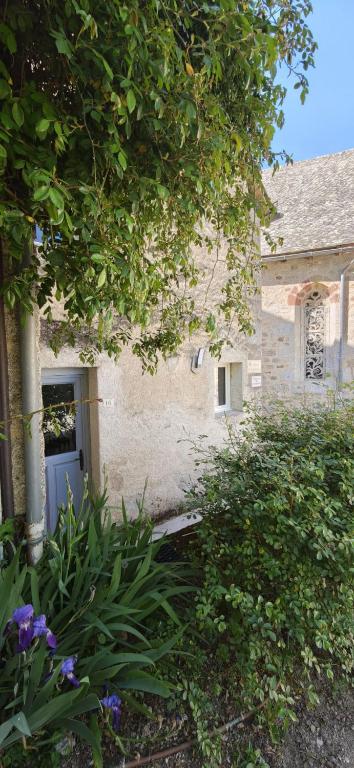 a house with a door and flowers in front of it at 16 Chemin De Compostelle in Sénergues
