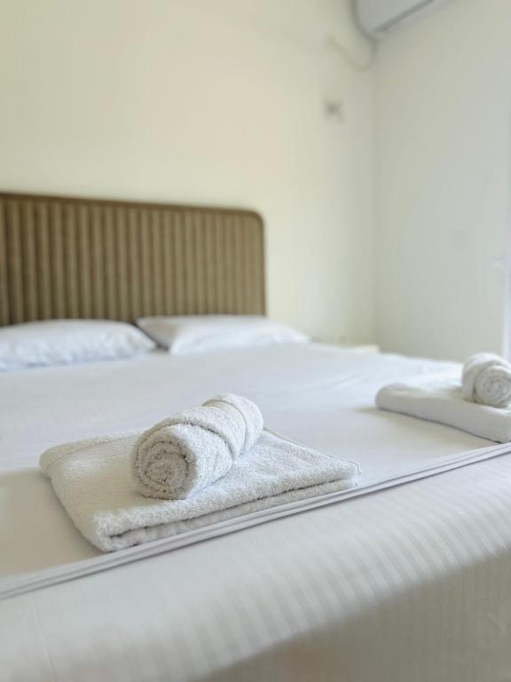two white towels are sitting on a bed at Apartmani ,,Del Mar'' in Ulcinj