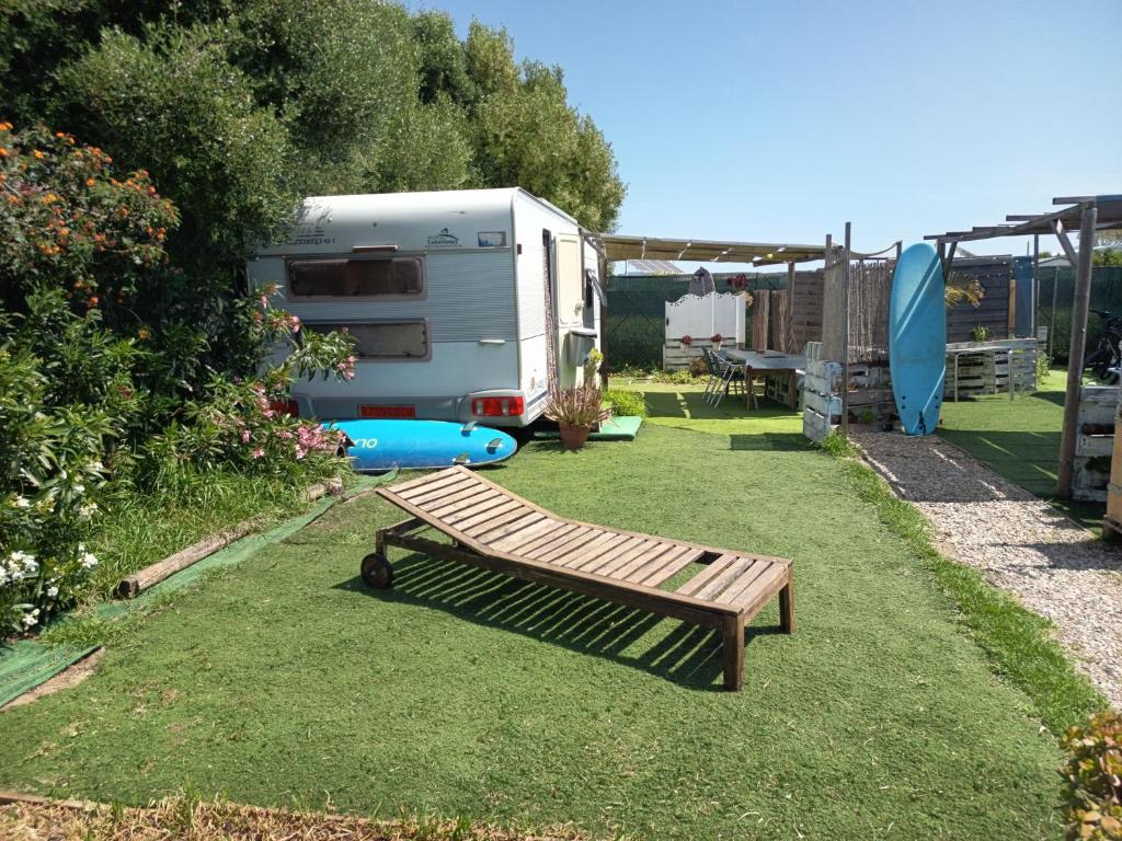 a garden with a bench and an rv and a tent at KairamSurf in El Palmar