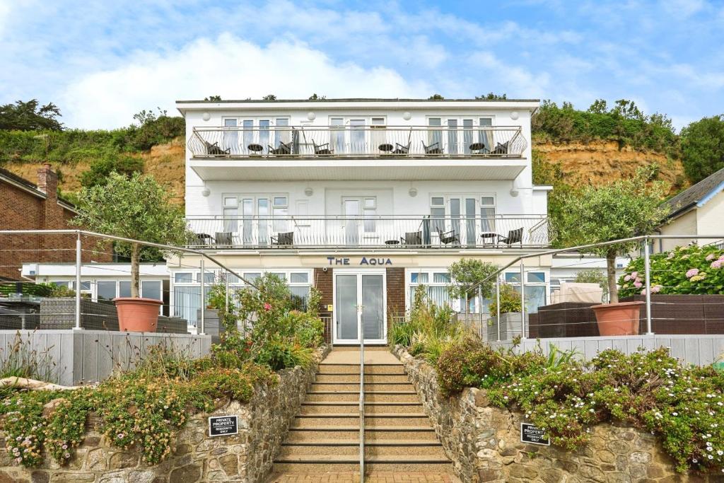 a white house with stairs leading up to it at Gurnard At The Aqua in Shanklin