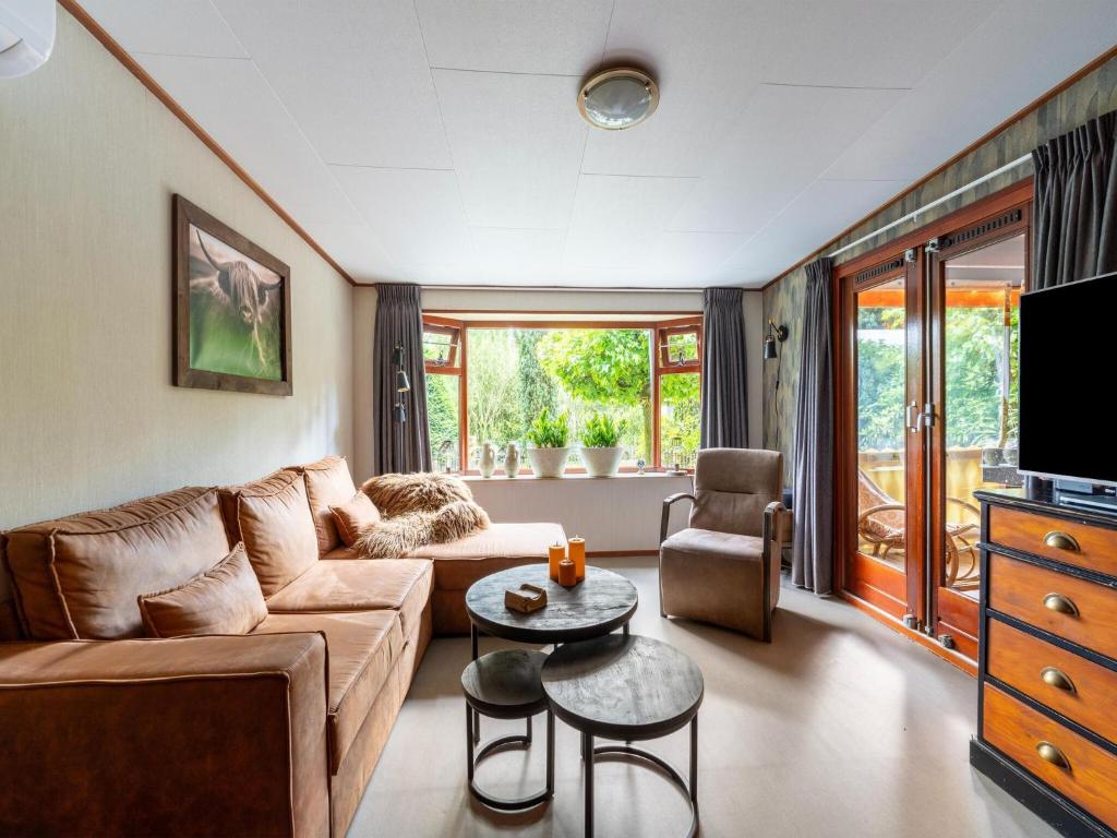 a living room with a couch and a table at Chalet in Stegeren near Forest and Pond in Stegeren
