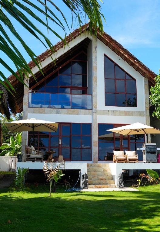 a house with two umbrellas in front of it at Villa Ombak in Katiet