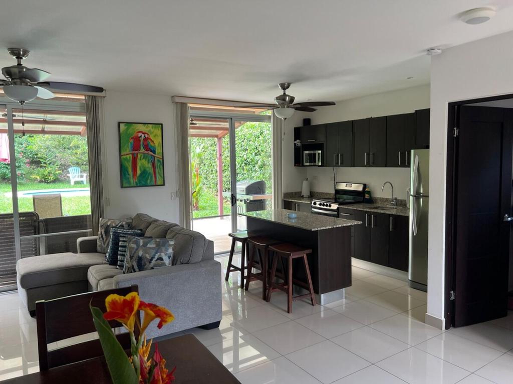 a kitchen and living room with a couch and a table at Private Pool, Walk to Beach -Los Delfines in Paquera