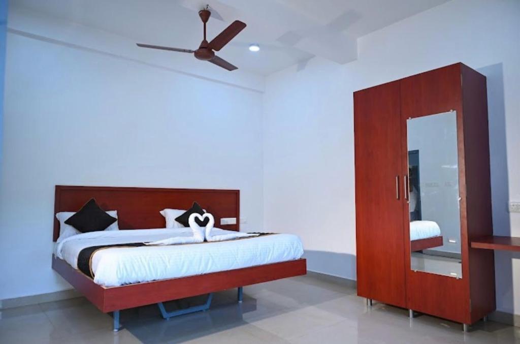 a bedroom with a bed and a ceiling fan at Joy Villa Homestay in Honāvar
