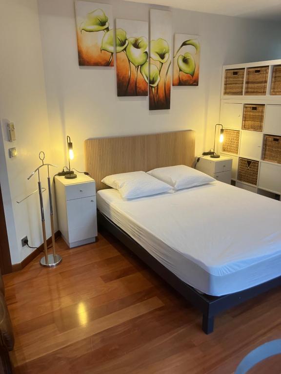 a bedroom with a bed and paintings on the wall at Chambre indépendante in Saint-Roman