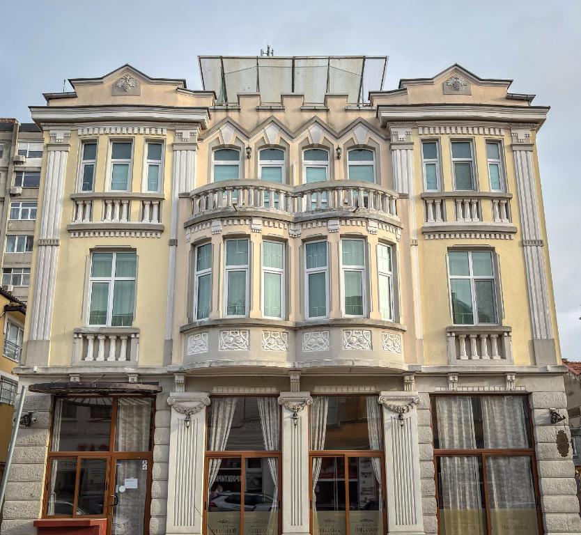 a large yellow building with a lot of windows at Family Hotel Chiplakoff in Burgas