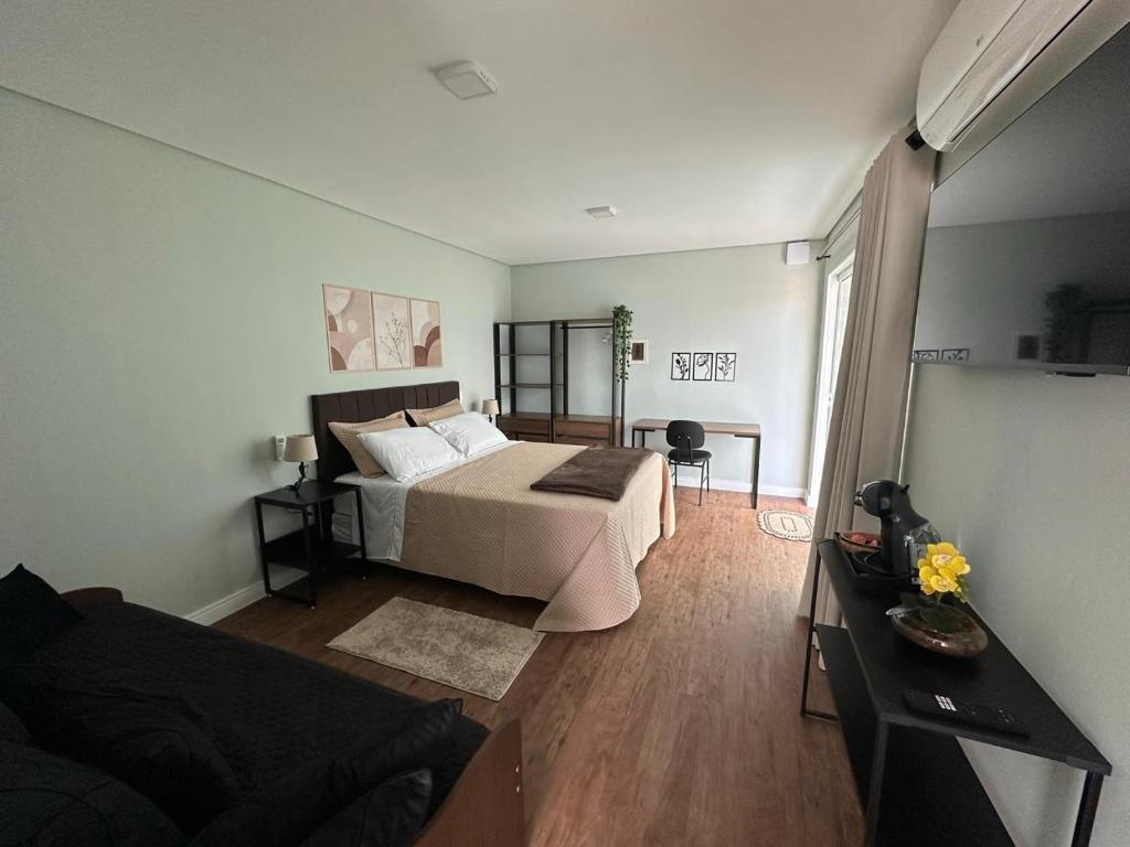 a bedroom with a bed and a couch in a room at Aconchego do Lago in Espirito Santo Do Pinhal