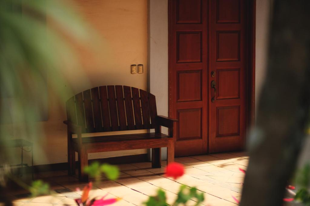 a wooden chair sitting in front of a door at Casa Aply in San Andrés Huayapan