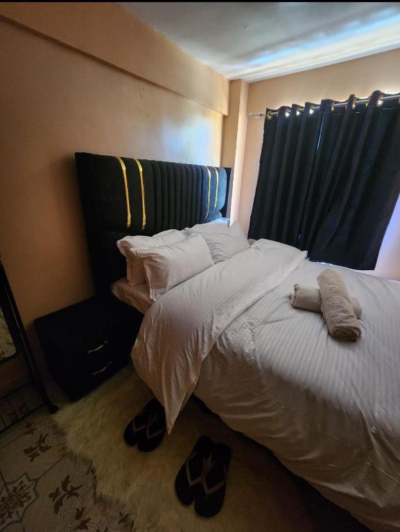 a bedroom with a bed with shoes on the floor at Pure excellence homes in Ruiru