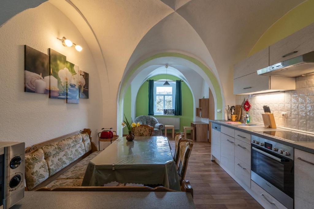 a kitchen with an arched ceiling and a table in a room at Ferienwohnung Reichel in Remptendorf