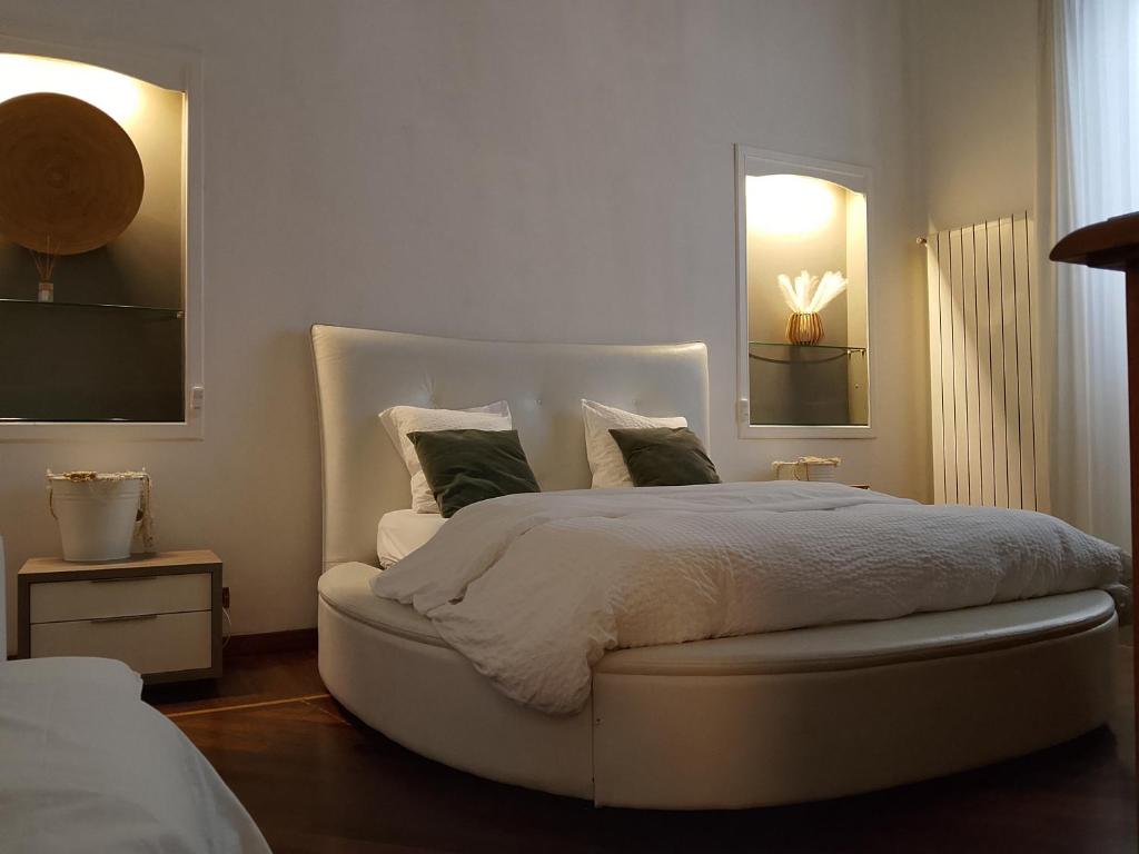 a bedroom with a white bed with a white headboard at queen 24 in Taranto