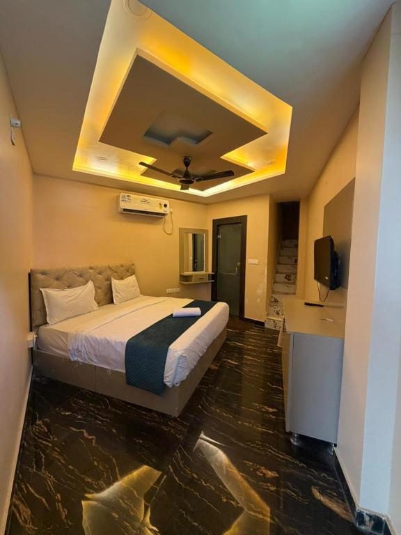 a bedroom with a large bed with a ceiling at Hotel Tapovan Hills in Rishīkesh