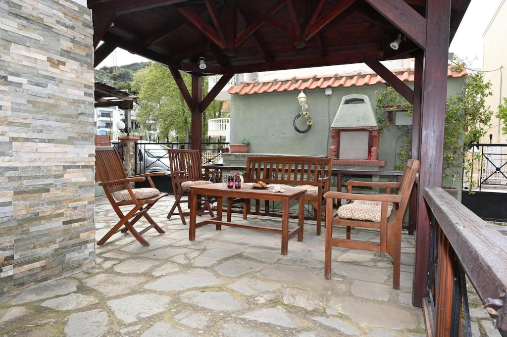 a patio with a table and chairs and a grill at Calm Breeze House in Nea Peramos