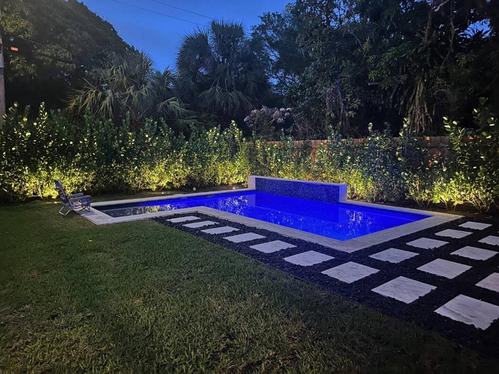 a garden with a blue pool in the grass at Northwood Revival in West Palm Beach