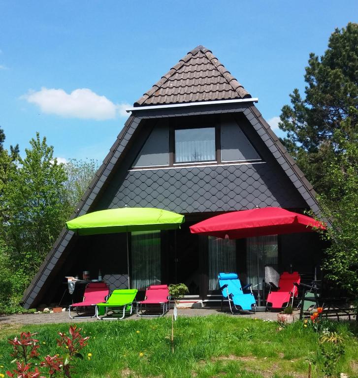 a group of chairs and umbrellas in front of a house at Ferienhaus Im Abendrot in Waldbrunn